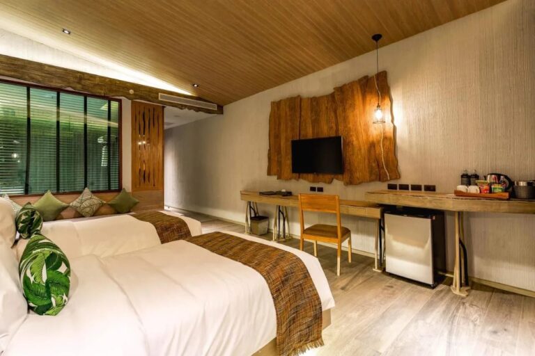 Een kamer met twee bedden, een zitbank onder het raam, een bureau en een theeblad