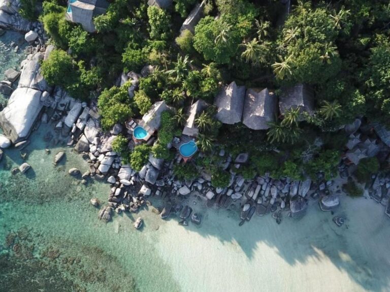 Luchtfoto van Koh Tao Cabana, met de cottages tussen de bomen, de rotsen en het witte zandstrand
