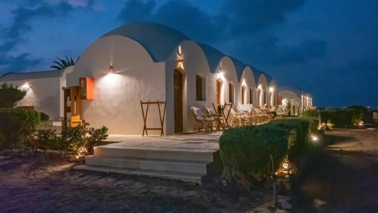 De chalets van Marsa Shagra Village, verlicht bij het vallen van de avond, met hun terrassen